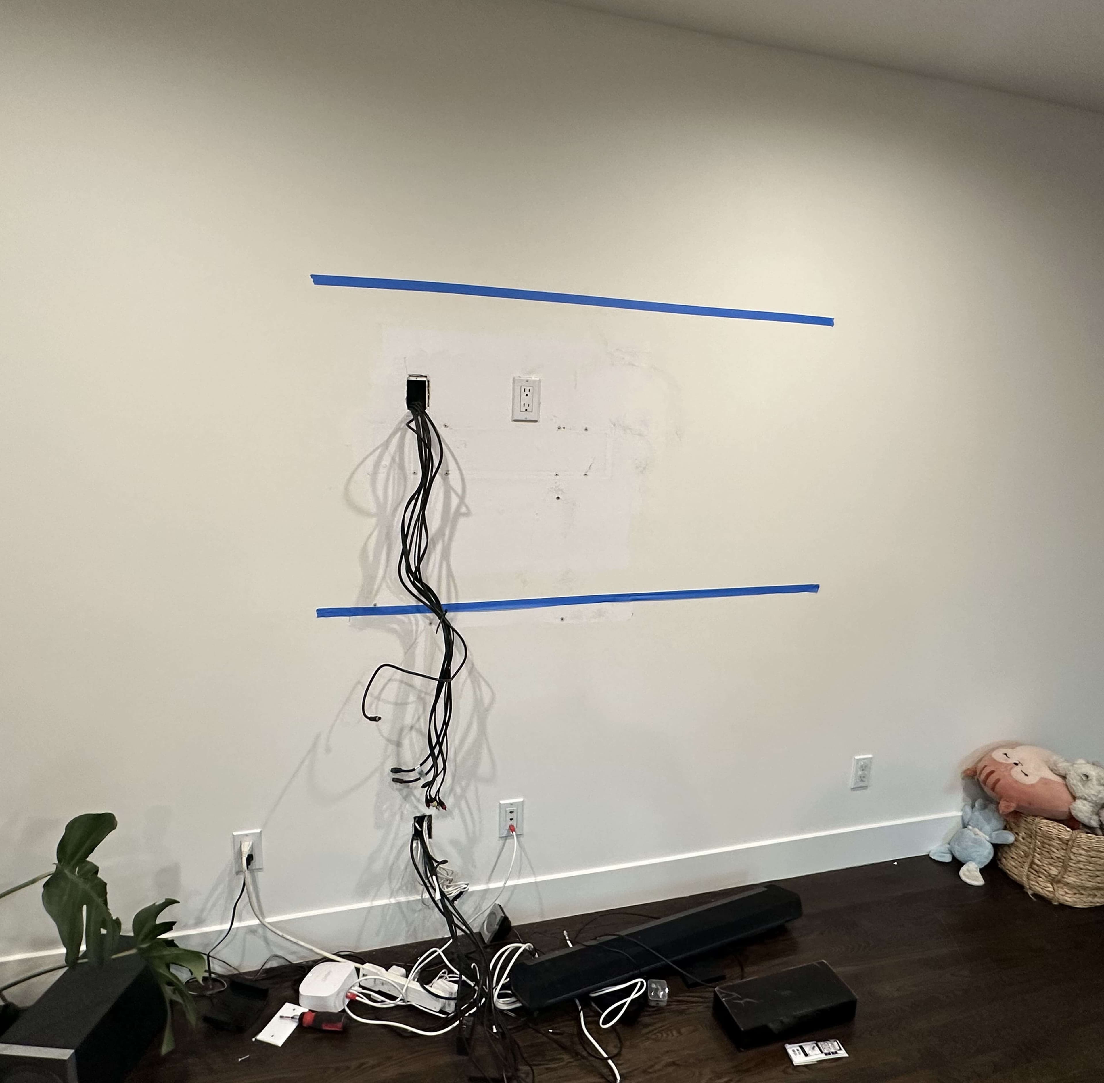 TV mounting before in-wall cable concealment with visible wires